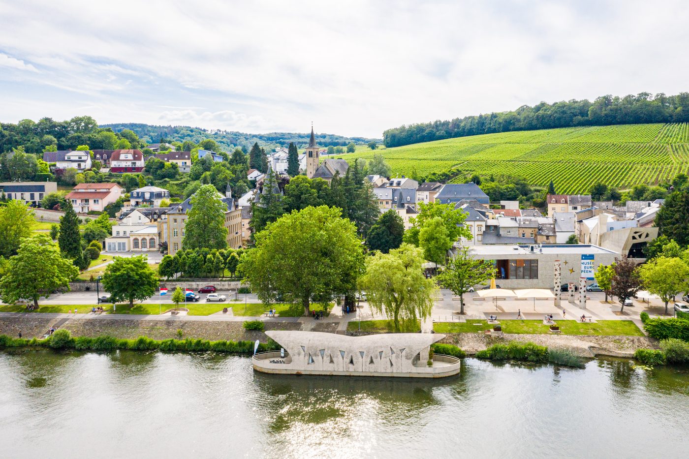 Schengen an der Mosel aus der Luft, mit Weinbergen und dem Europäischen Museum am Ufer